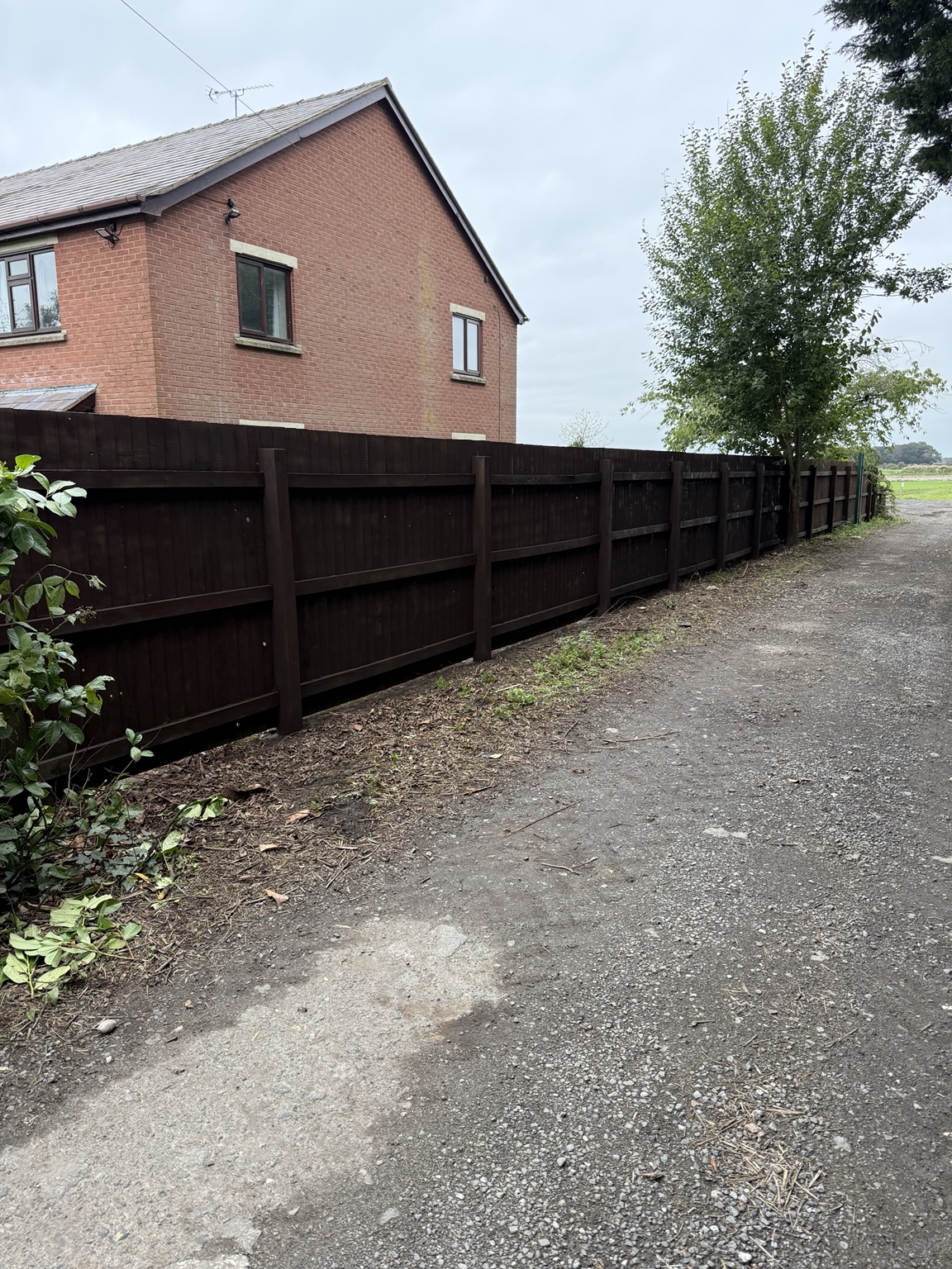 Same fence after maintenance, with a consistent dark finish