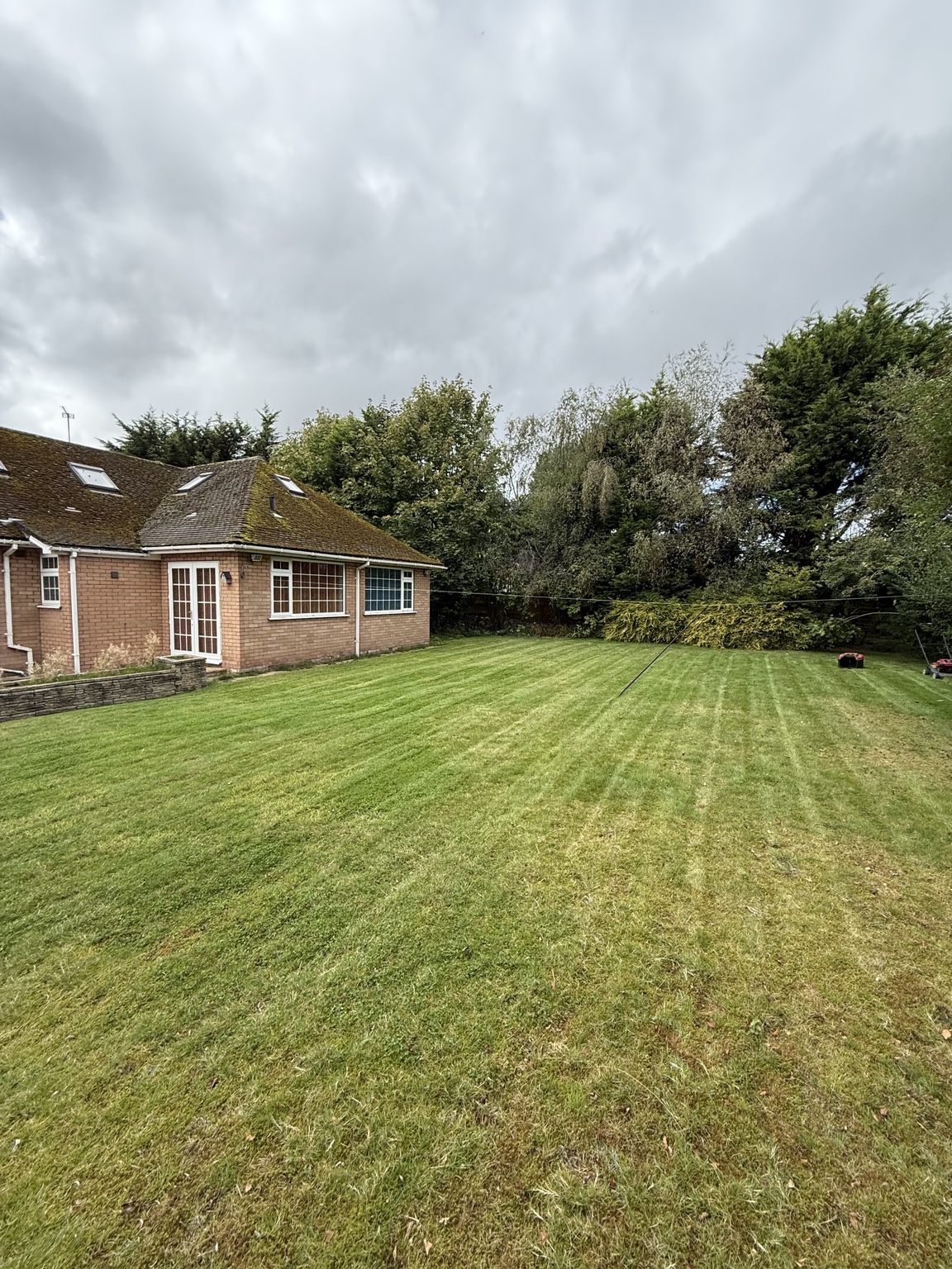 Freshly mown lawn with tidy stripes beside a home